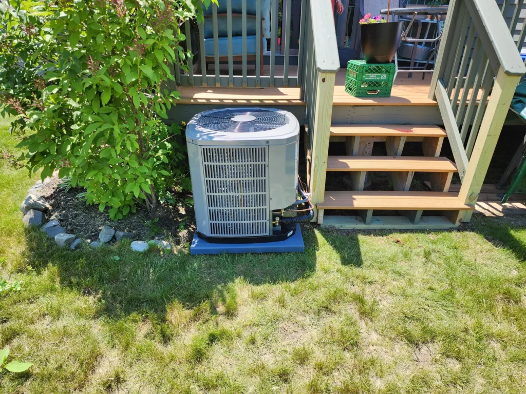 Central air conditioner condenser in a landscaped yard