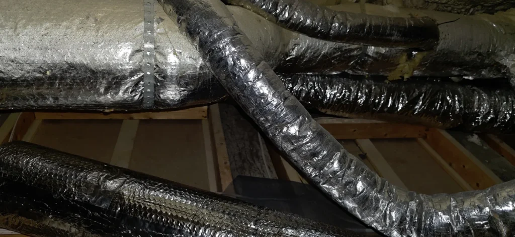 Insulated supply ducts routed through an attic for a ducted system