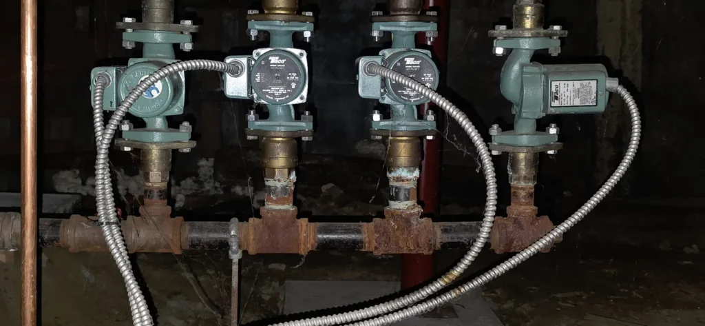 Row of boiler zone circulator pumps on copper piping