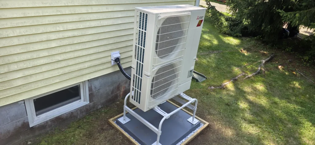 Cold-climate heat pump outdoor unit installed beside a home
