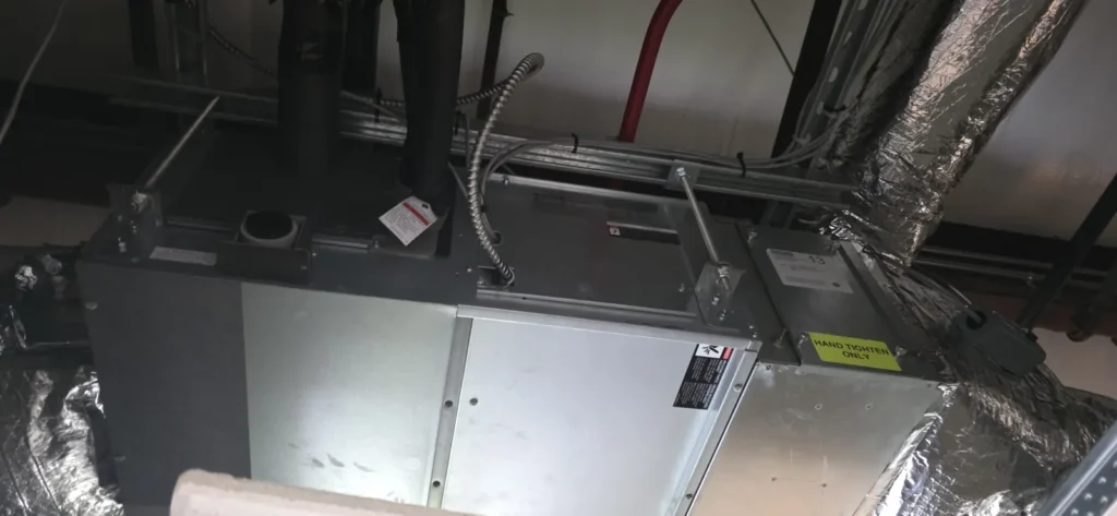Slim ducted mini-split indoor unit mounted overhead with duct connections