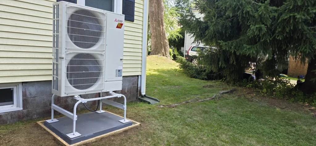 Air-source heat pump outdoor unit on a raised stand