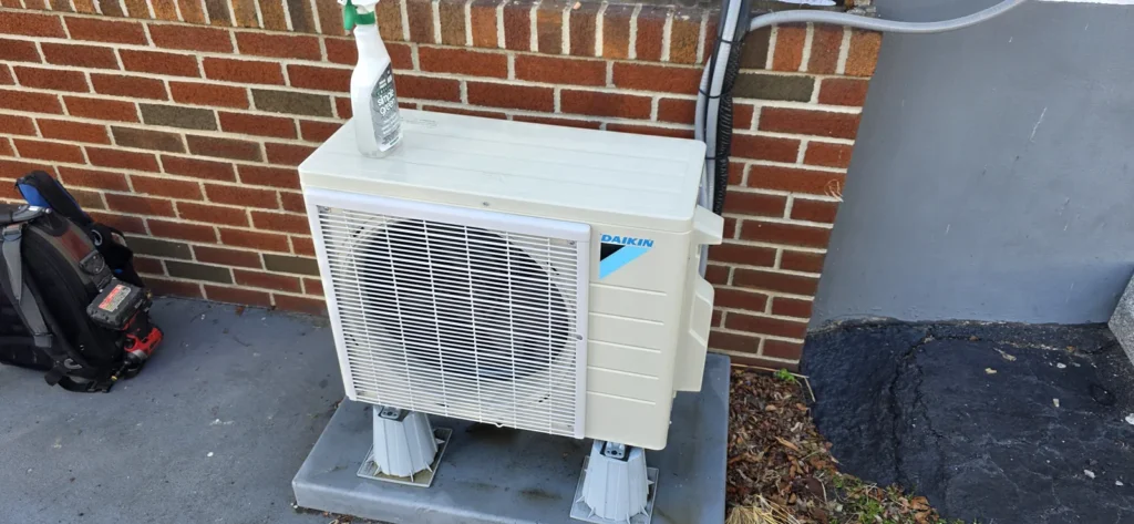 Mini-split outdoor unit installed against a brick wall