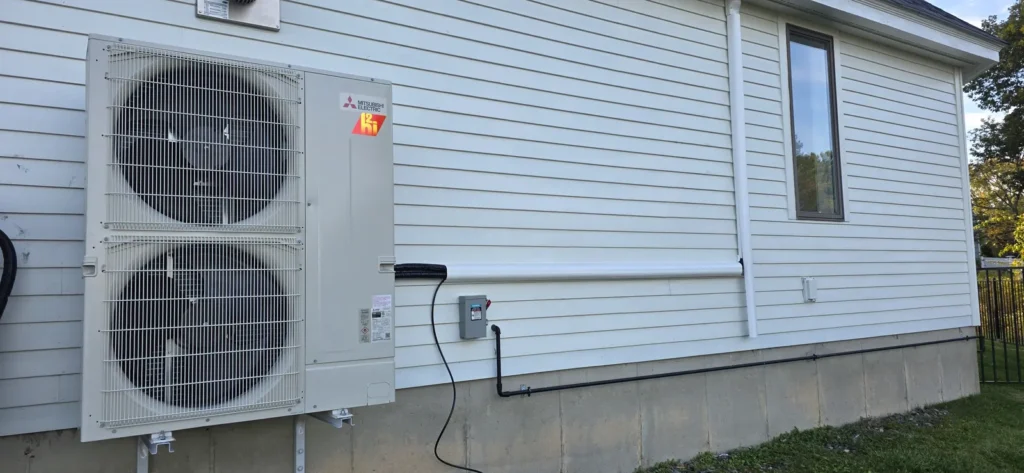 Ductless mini-split outdoor unit mounted beside a home
