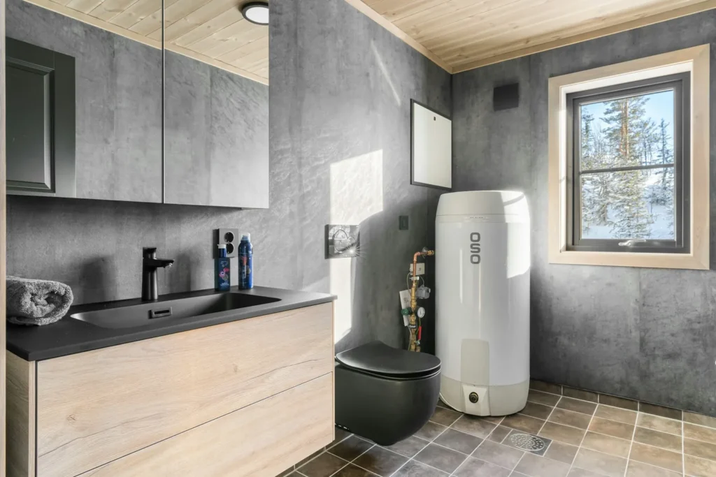Newly installed tank water heater in a modern bathroom with a window
