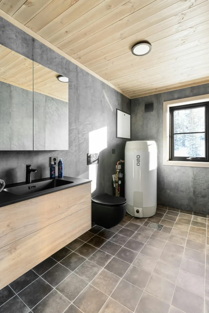 Floor-standing tank water heater in a modern bathroom with gray stone tile
