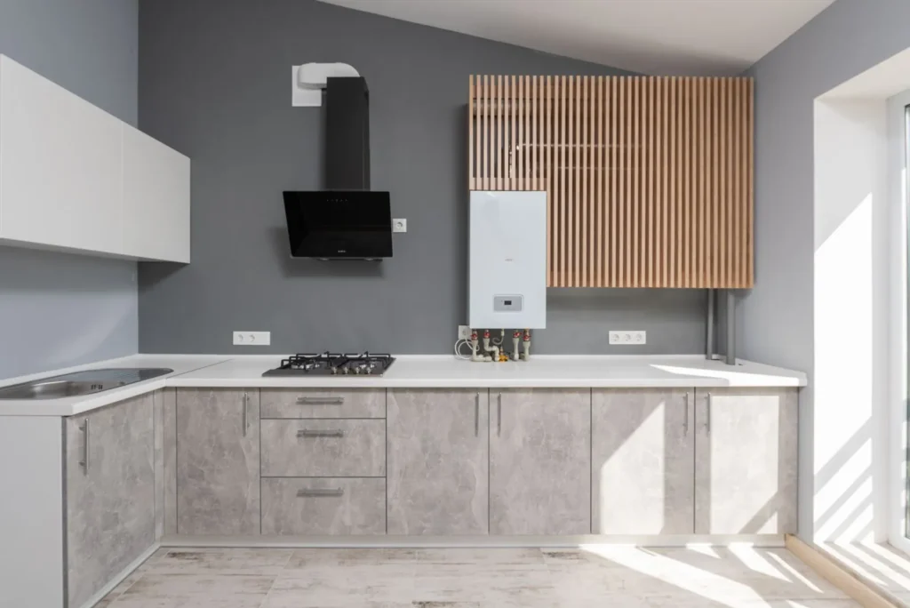 Tankless water heater installed on the wall of a modern gray kitchen