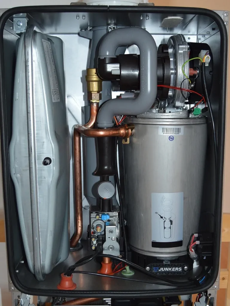 Inside a wall-hung gas condensing boiler showing heat exchanger and piping