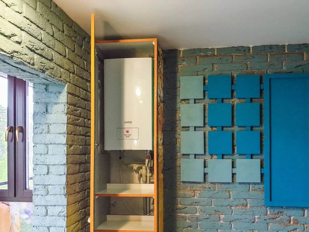 Wall-mounted gas water heater neatly installed in a tiled utility niche