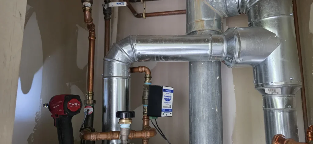 Tank water heater with vent piping in a basement
